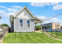 Charming home with a well-manicured lawn and inviting front porch with concrete steps at 1015 N Beville Ave, Indianapolis, IN 46201