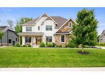 Charming two-story home with a combination of white siding and stone accents, plus a beautifully landscaped front yard at 10505 Golden Bear Way, Noblesville, IN 46060