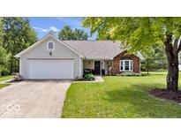 Charming single-story home featuring a two-car garage and a well-manicured lawn at 11041 Limbach Cir, Indianapolis, IN 46236