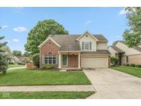 Charming two-story home with brick accents, a well-manicured lawn, and a two car garage at 11051 Oakridge Dr, Fishers, IN 46038