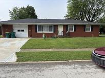 Charming single-story red brick home with a well-maintained front yard and attached garage at 1422 Dallas Dr, Plainfield, IN 46168