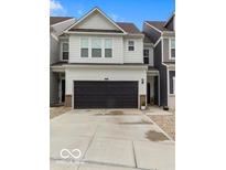 Charming two-story home with a black garage door, paved driveway, and gravel landscaping at 14350 Ludwell Ct, Fishers, IN 46037