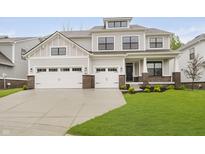 Beautiful two-story home featuring a three-car garage, professional landscaping, and neutral-colored siding at 1510 Stonehaven Dr, Westfield, IN 46074