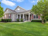 Charming stone home with red shutters and a well-manicured lawn on a sunny day at 15292 Slateford Rd, Noblesville, IN 46062