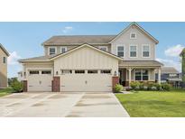 Charming two-story home featuring a three-car garage and well-manicured lawn at 15418 Tattersalls Ln, Fishers, IN 46040