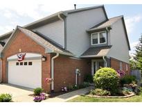 Charming home exterior featuring a brick facade, attached garage, and manicured landscaping at 213 Golf Ct, Greenwood, IN 46143