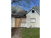 An exterior view of a distressed single-Gathering home with boarded-up windows needing full rehab at 330 N Lasalle St, Indianapolis, IN 46201