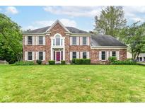 Charming brick home featuring a landscaped front yard, white shutters, and a statement purple front door at 3772 Christina Ct, Carmel, IN 46033