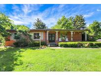 Charming brick ranch-style home with well-manicured lawn and inviting front porch at 415 Woodhill Dr, Indianapolis, IN 46227