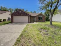 Charming single-story brick home with a two-car garage and a well-maintained front lawn at 4825 May Ridge Ln, Indianapolis, IN 46254