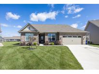Brick home featuring an attached two-car garage and a well-manicured lawn at 5196 Canberra Ct, McCordsville, IN 46055