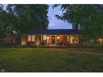 Charming brick home with a well-maintained lawn and cozy front porch seating area at 5601 Rosslyn Ave, Indianapolis, IN 46220