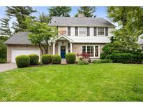 Charming two-story home with a well-manicured lawn and landscaped yard featuring mature trees and manicured shrubbery at 6020 Gladden Dr, Indianapolis, IN 46220