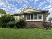 Charming brick home featuring a cozy front yard and classic architectural details at 701 N Gladstone Ave, Indianapolis, IN 46201