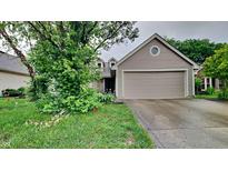 Charming single-Gathering home features a tan exterior, two-car garage, and mature trees at 7859 Chesapeake E Dr, Indianapolis, IN 46236