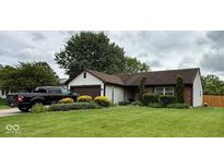 Charming home with a well-manicured lawn, mature landscaping, and a driveway featuring a black truck at 8123 Summertree Ct, Indianapolis, IN 46256