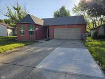 Charming single-story brick home with attached two-car garage and a concrete driveway at 8810 Summer Walk E Dr, Indianapolis, IN 46227