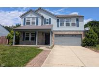 Charming two-story home featuring a covered front porch and two car garage on a sunny day at 9206 Huntleigh Cir, Plainfield, IN 46168