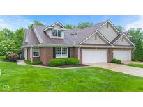 Charming brick home featuring a three-car garage and well-manicured landscaping at 11510 Monon Farms Ln, Carmel, IN 46032