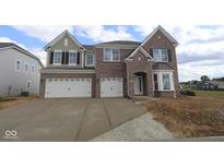 New brick home showcasing a spacious driveway and an attached two-car garage at 12403 Fresh Stock Dr, Noblesville, IN 46060