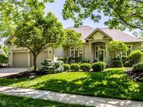 Charming brick home with manicured lawn, mature trees, and welcoming entryway, perfect for suburban living at 13069 Abraham Run, Carmel, IN 46033