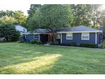 Charming blue home featuring a well-maintained front yard, mature tree and beautiful landscaping at 1309 Rolling Ct, Westfield, IN 46074