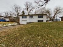 Charming two-story white home with an attached garage and a well-maintained front yard on a cloudy day at 1325 Northcrest Dr, Anderson, IN 46012