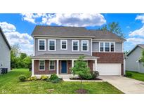 Charming two-story home featuring gray siding, brick accents, a well-manicured lawn, and an attached two-car garage at 1384 Horse Shoe, Greenwood, IN 46143