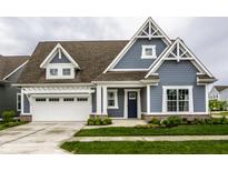 Charming home featuring blue siding, a brown roof, a white garage door and beautifully landscaped front yard at 15596 Edenvale Dr, Westfield, IN 46074