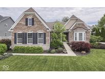 Charming brick home with manicured lawn, beautiful landscaping, and elegant architectural details at 187 N Bend Dr, Greenwood, IN 46142