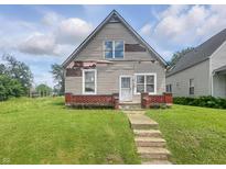 Modest two-story home featuring vinyl siding, brick accents, and a well-maintained lawn at 1947 N Parker Ave, Indianapolis, IN 46218