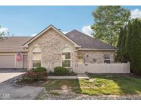 Charming brick home featuring well-manicured landscaping and a quaint, fenced front yard at 6711 Bridgefield Way, Indianapolis, IN 46254