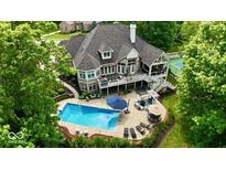 Expansive home with a backyard oasis featuring a pool, hot tub, tennis court, and multiple seating areas at 7016 Royal Oakland Way, Indianapolis, IN 46236