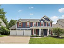 Charming two-story home boasts a three-car garage, well-manicured lawn, and classic curb appeal at 8241 Holmard Pl, Indianapolis, IN 46259