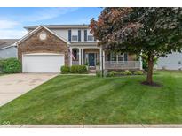 Charming two-story home with brick accents, covered porch, landscaped yard, and attached two-car garage at 9756 Brook Meadow Dr, McCordsville, IN 46055