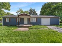 Charming single-story home with blue siding, wooden shutters, and a well-maintained front lawn at 1002 Collier St, Indianapolis, IN 46241