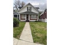 Charming two-story home with a brick foundation, front yard, and sidewalk leading to the front door at 1021 W 37Th St, Indianapolis, IN 46208