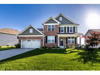 Charming two-story brick home with a well-manicured lawn and attached two-car garage, perfect for Gathering living at 1065 Park Ct, Avon, IN 46123