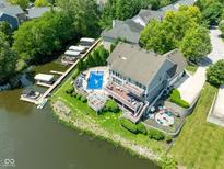 Stunning aerial view of the property showcasing a private pool, boat docks and waterfront access on a sunny day at 11061 Mast Ct, Fishers, IN 46040