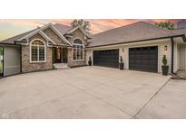 Beautiful stone and siding home featuring a spacious driveway and a three-car garage at 11911 W Grandview Dr, Columbus, IN 47201