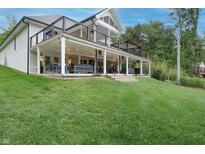 Expansive two-story deck with outdoor seating, ceiling fans, and string lights offers stunning outdoor living space at 11911 W Grandview Dr, Columbus, IN 47201