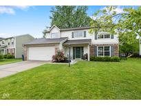 Charming two-story home with attached two-car garage, lush lawn, brick accents and manicured landscaping at 12524 Trophy Dr, Fishers, IN 46038
