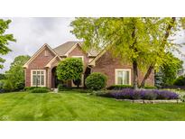 Charming brick home featuring a well-manicured lawn and professionally landscaped front yard at 12539 Pebblepointe Pass, Carmel, IN 46033