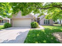 Charming brick home with a well-manicured lawn, mature trees, and an attached two-car garage at 13911 Naples Dr, Fishers, IN 46038