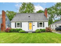 Charming single-story home featuring a brick chimney, mature landscaping and a bright yellow front door at 2526 Dell Zell Dr, Indianapolis, IN 46220