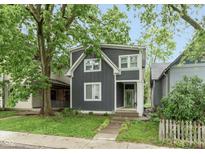 Charming two-story home featuring a modern gray facade, white trim, and a vibrant green front door at 326 Parkway Ave, Indianapolis, IN 46225