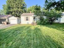 Charming home with a well-maintained lawn, detached garage, and mature trees in a quiet neighborhood at 3321 Sycamore Dr, Columbus, IN 47203