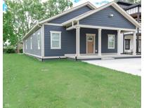 Charming blue house featuring a covered front porch and well-manicured lawn at 4625 W Naomi St, Indianapolis, IN 46241