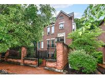 Charming brick home featuring a gated front entrance and landscaped yard, creating a welcoming curb appeal at 558 E Vermont St, Indianapolis, IN 46202