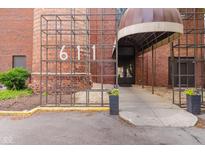 Brick building entrance with a covered walkway and decorative iron number display; planter boxes flank the entrance at 611 N Park Ave # 108, Indianapolis, IN 46204